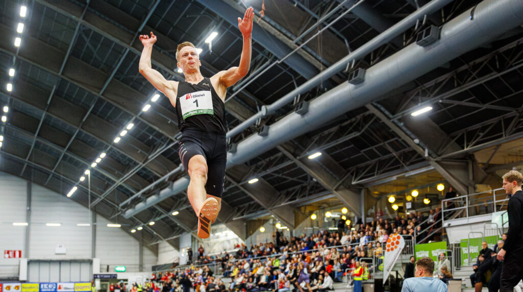 Pituushyppääjä Kristian Pulli ilmassa, yleisöä taustalla